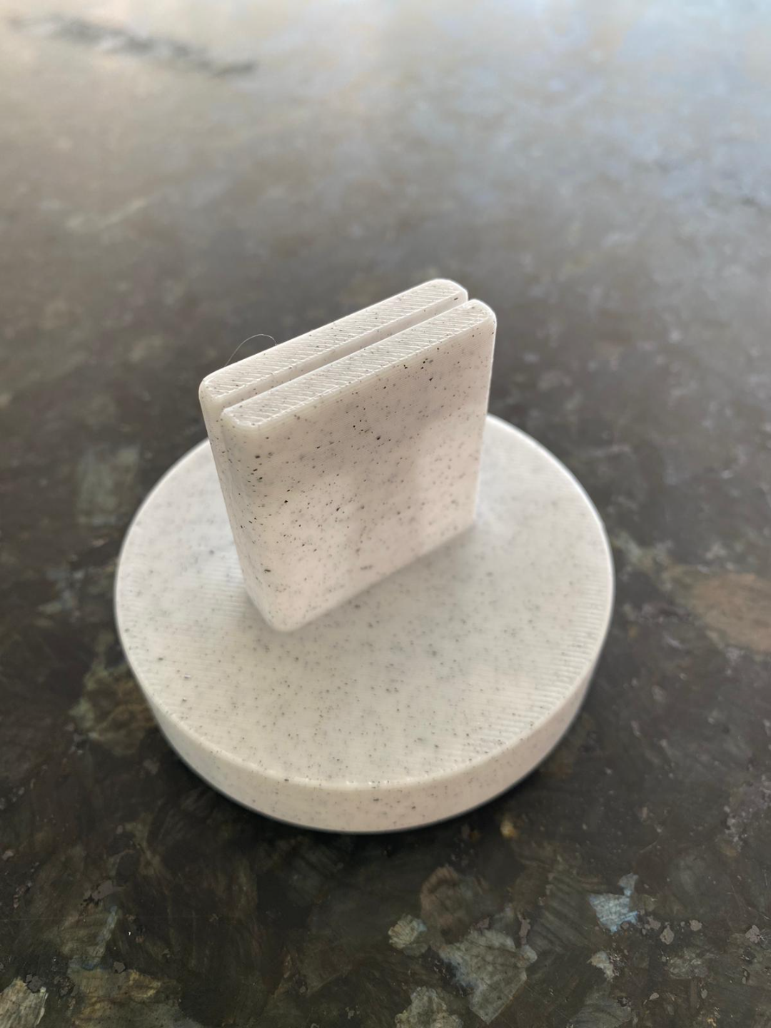 Geometric card holder displaying a small white postcard
