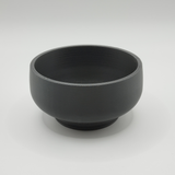 Curved bonsai pot on windowsill with small succulent plant