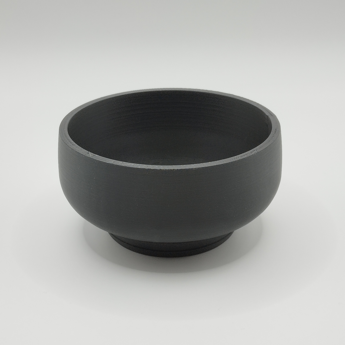 Curved bonsai pot on windowsill with small succulent plant