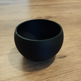 Overhead view of a minimalist key and coin bowl with smooth interior surface