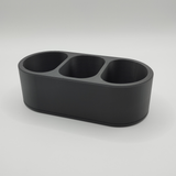 Minimalist remote caddy styled on wooden coffee table with remotes and small items inside