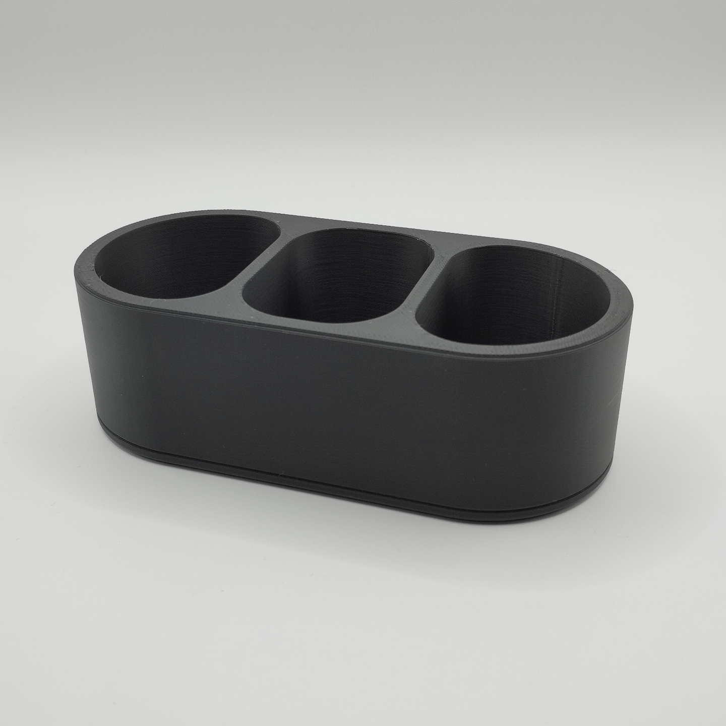 Minimalist remote caddy styled on wooden coffee table with remotes and small items inside