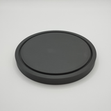 Minimalist round coaster beneath a warm ceramic mug on a wooden table
