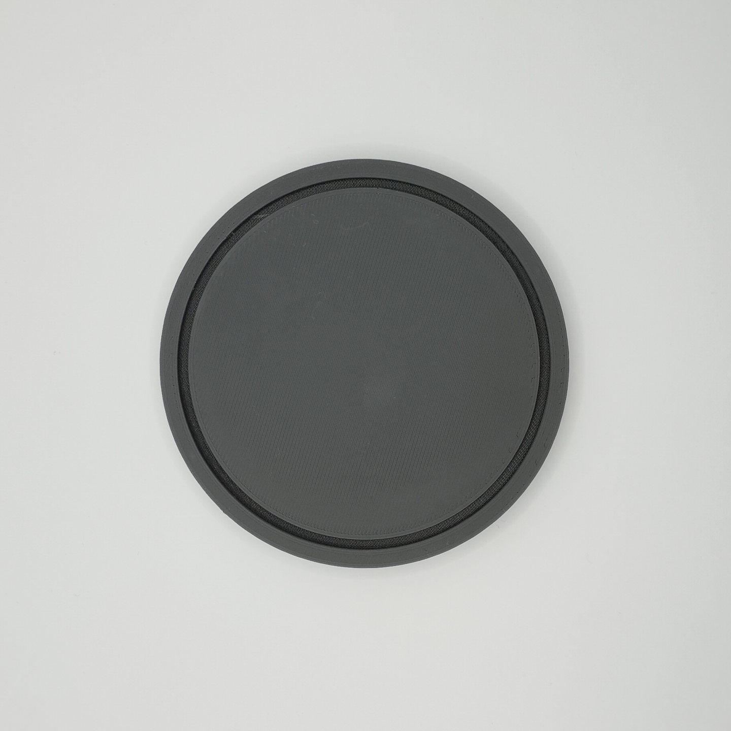 Close detail of the coaster's flat, refined surface texture