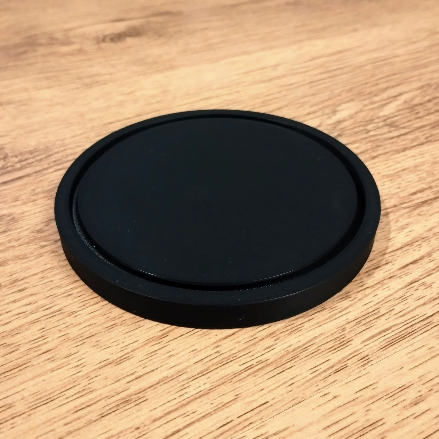 Smooth round minimalist coaster viewed from above, clean geometry and matte surface
