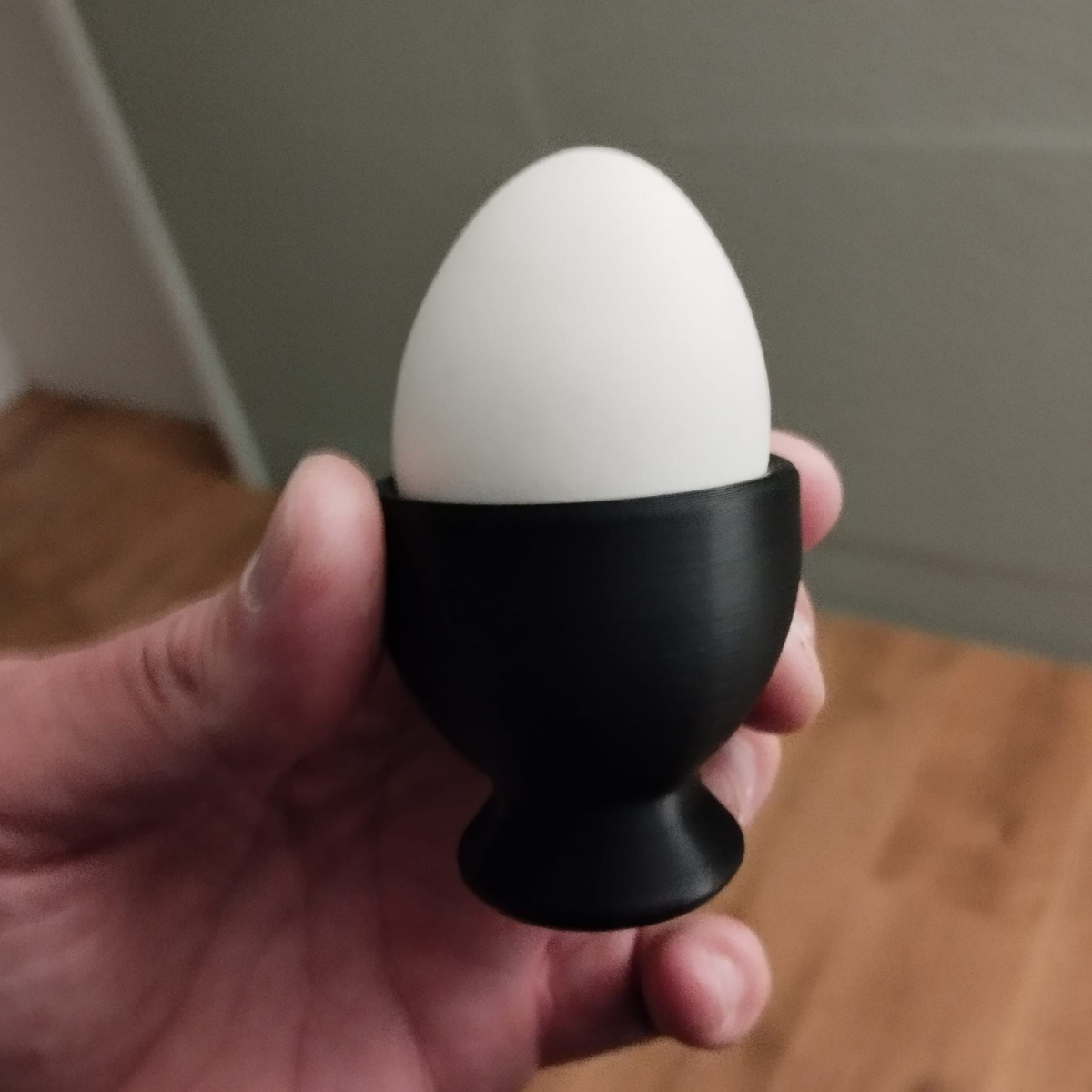 Close-up of a matte white minimalist egg cup showing clean cone form