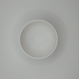 Soft light across ribbed bowl surface creating shadow texture