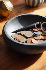 Flat design key and coin bowl in white, close-up view showing geometric silhouette