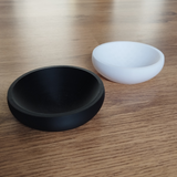 Flat design key and coin bowl in white, close-up view showing geometric silhouette