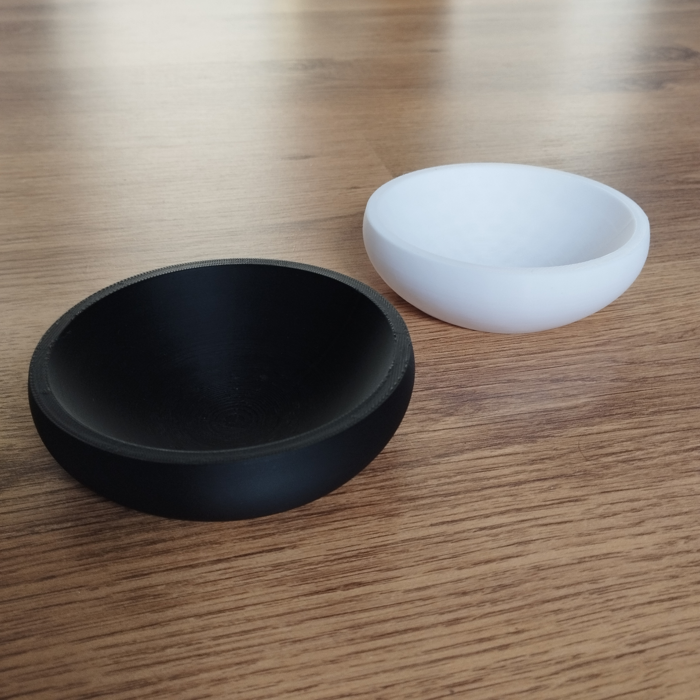 Flat design key and coin bowl in white, close-up view showing geometric silhouette