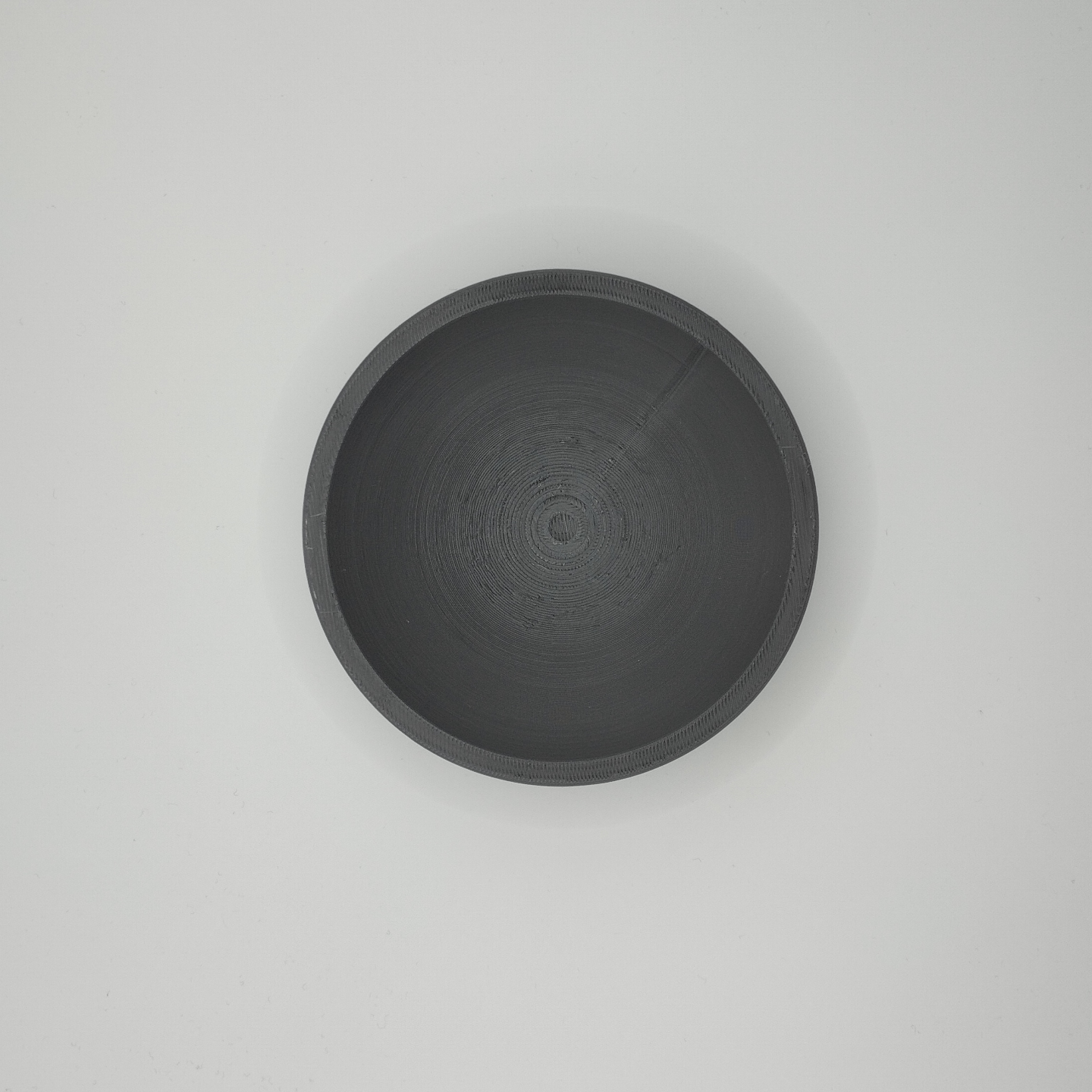 Flat design key and coin bowl in white, close-up view showing geometric silhouette