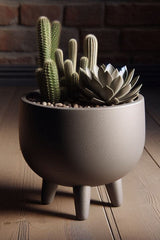 Mid-century plant pot with four feet shown in warm light, clean geometric lines
