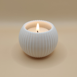 Minimalist ribbed tealight holder with LED candle in warm light