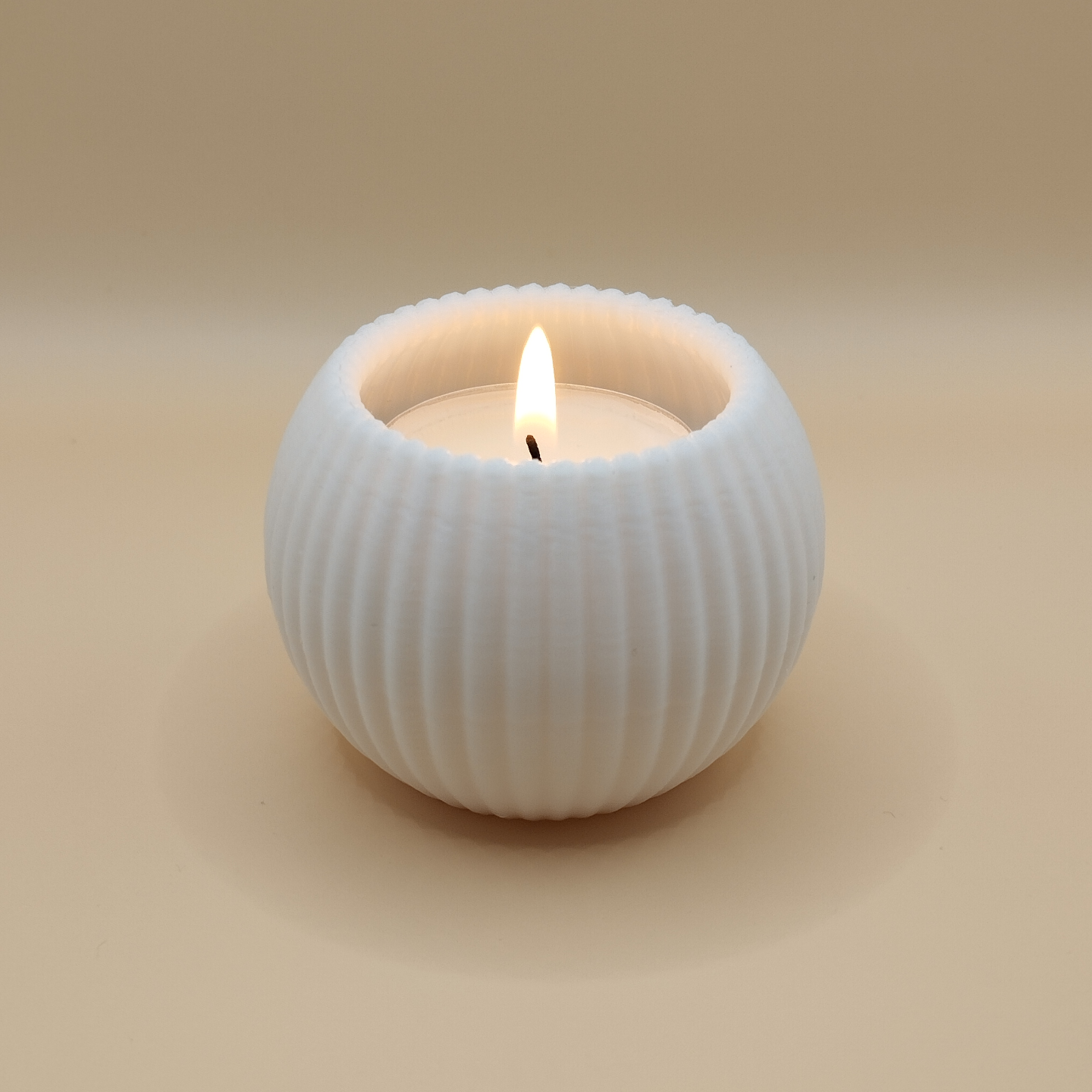 Minimalist ribbed tealight holder with LED candle in warm light