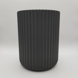 Minimalist ribbed kitchen holder filled with wooden spoons and utensils on countertop