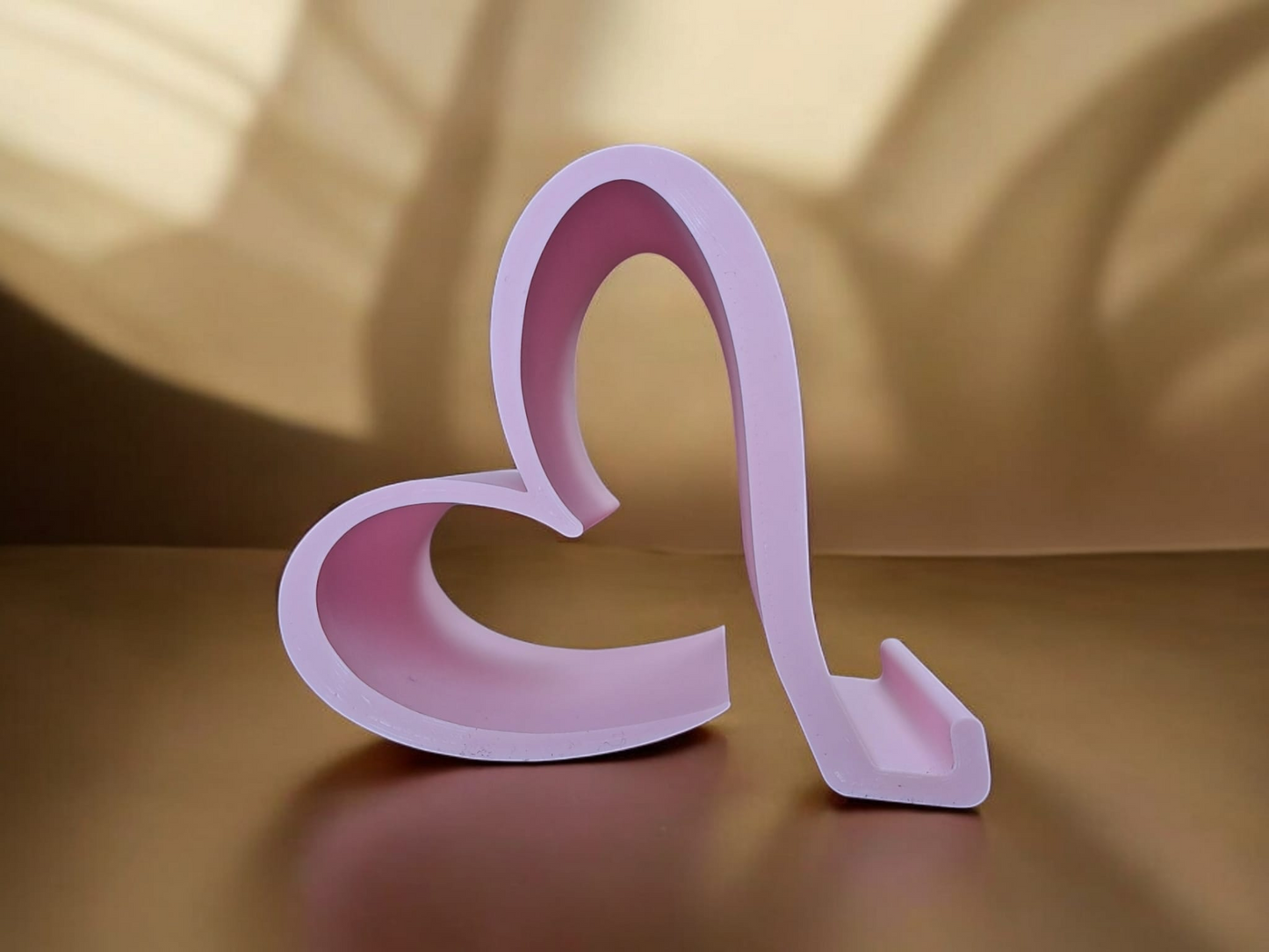 Valentine phone holder placed on a desk beside a smartphone and notebook
