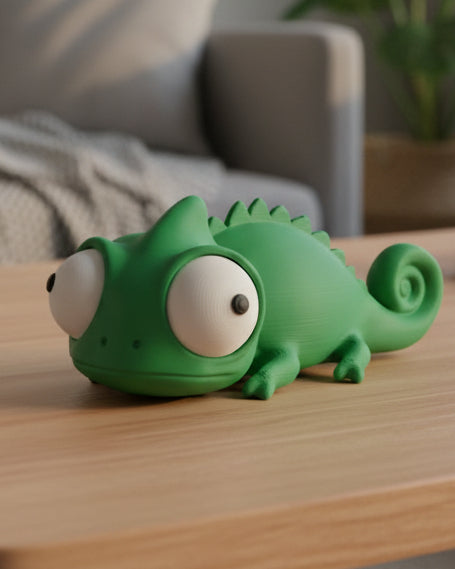 Close-up of goofy chameleon figure with large movable googly eyes on a white surface