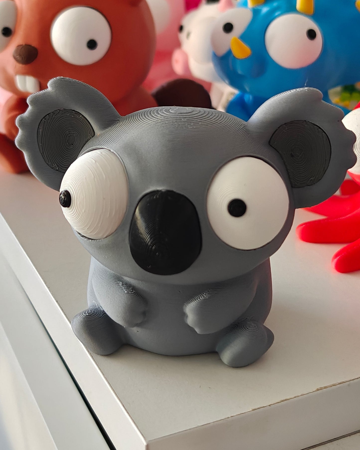 Close-up of the koala figure's large repositionable googly eyes showing different expressions