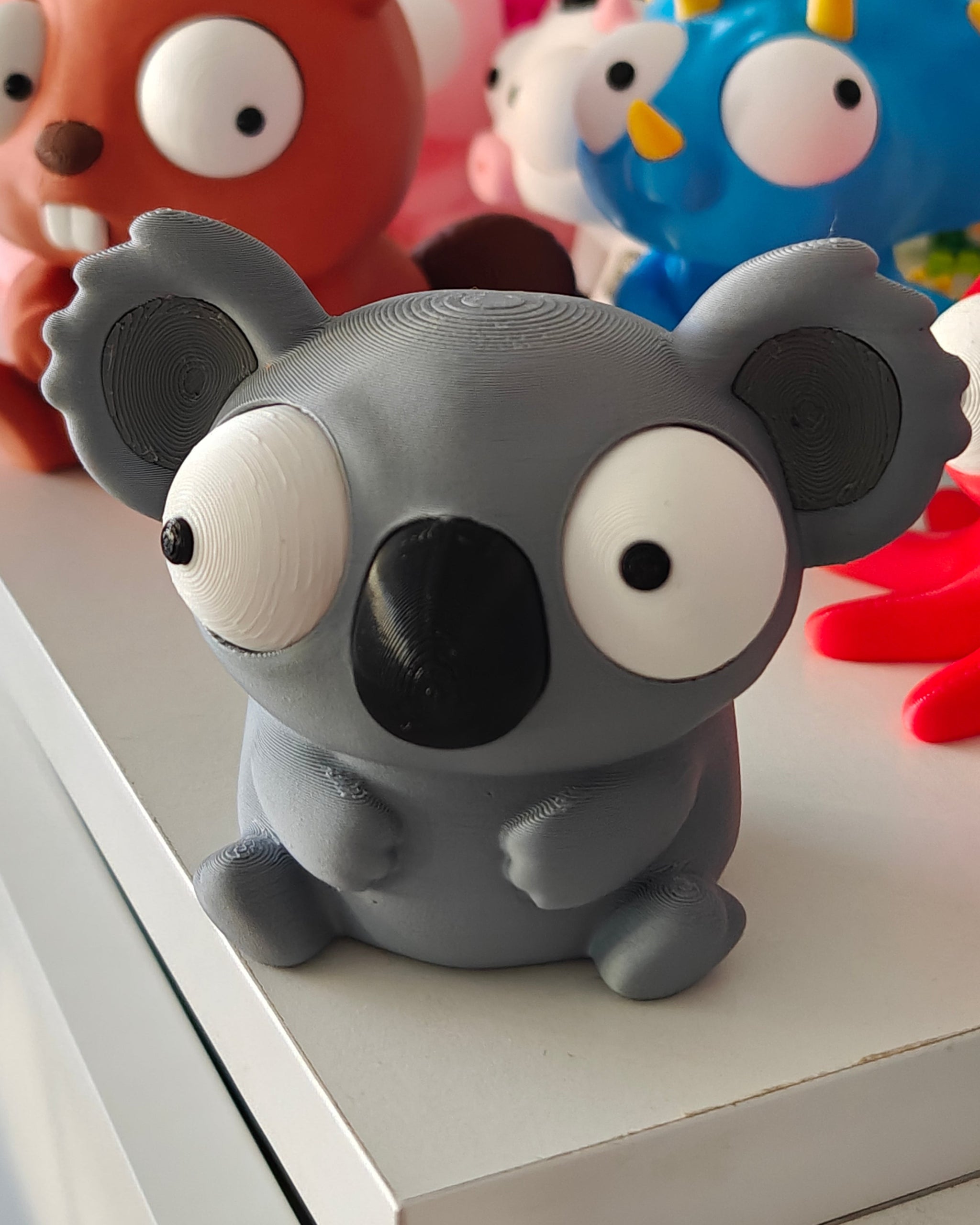Close-up of the koala figure's large repositionable googly eyes showing different expressions