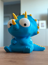 Goofy triceratops figure with movable googly eyes, close-up on white background