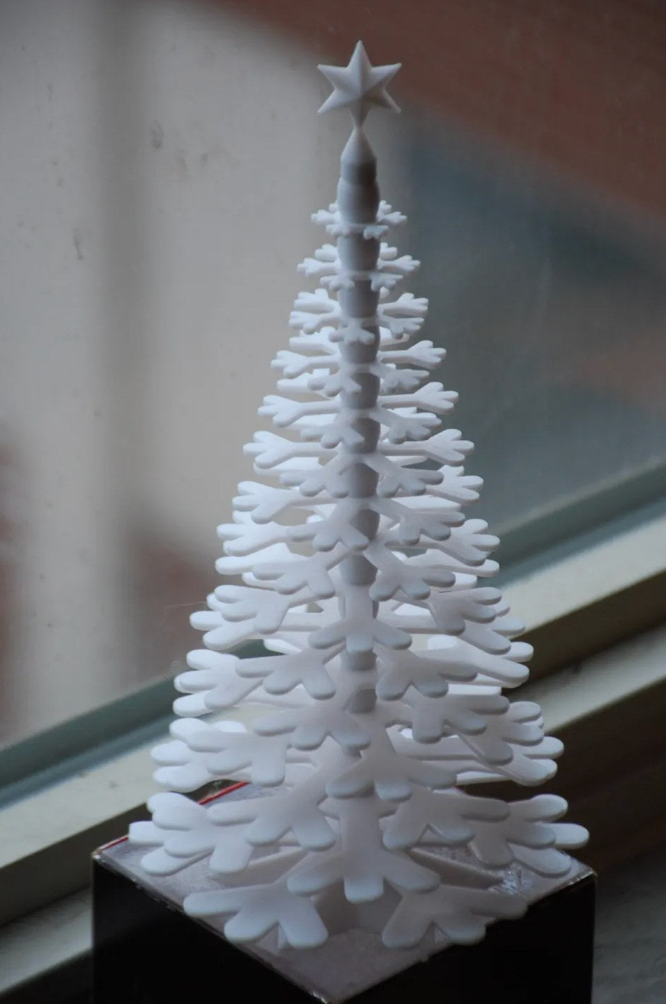Weihnachtsbaumfigur aus Schneeflocken mit Stern