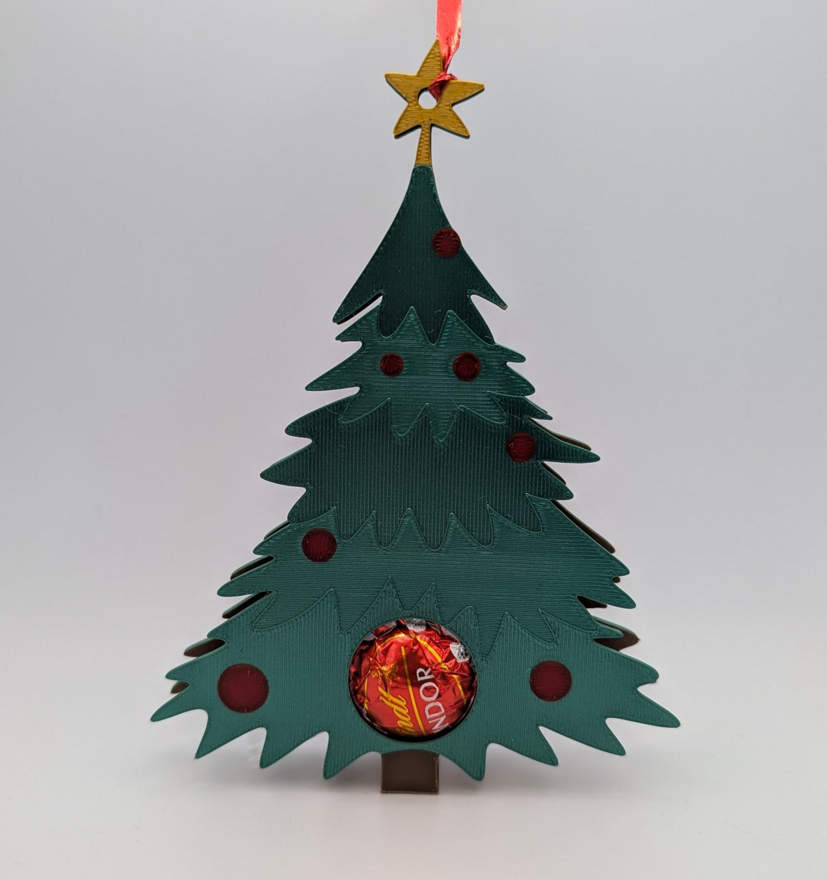 Weihnachtsbaumanhänger, der eine Schokokugel versteckt