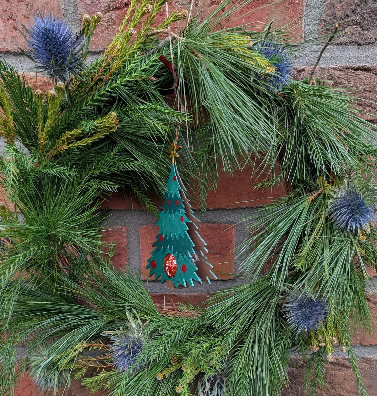 Weihnachtsbaumanhänger, der eine Schokokugel versteckt