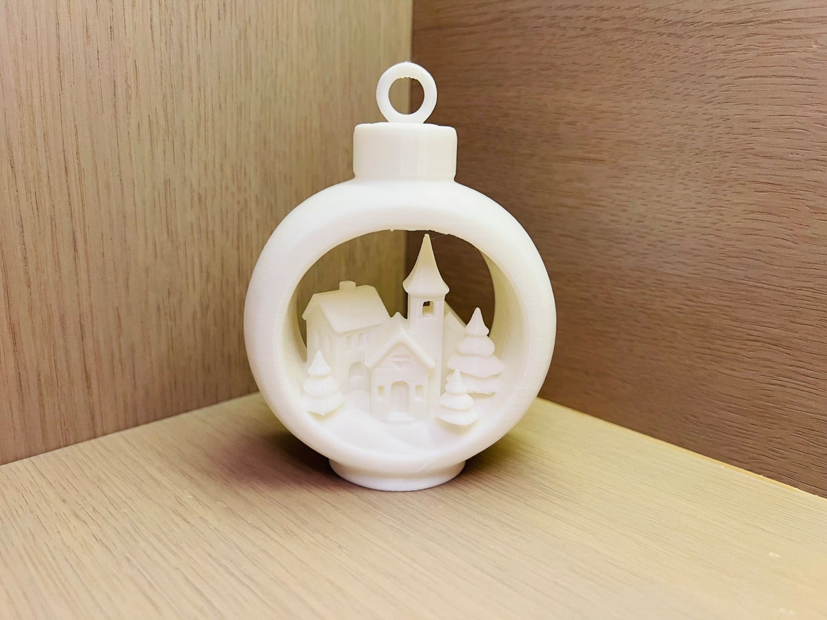Christbaumschmuck mit Winterdorf im runden Rahmen