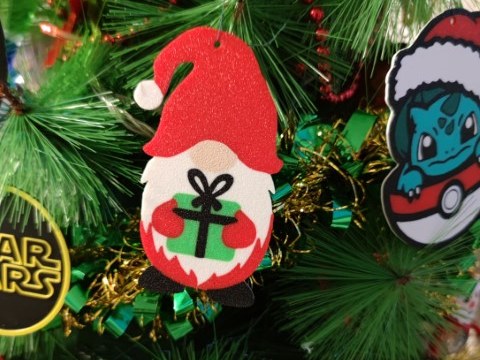 Festlicher Wichtel mit roter Mütze und Geschenk in den Händen
