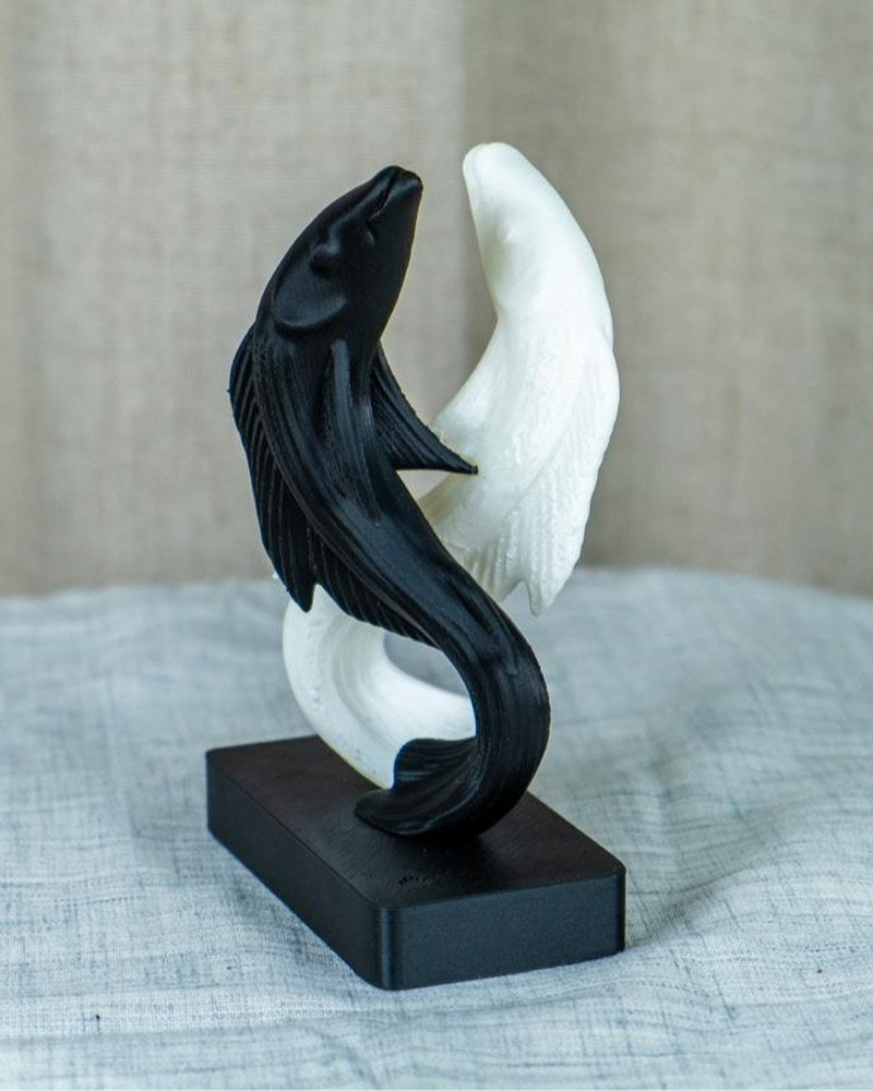 Yin-yang koi fish sculpture in black and white, detailed fins and scales, front view