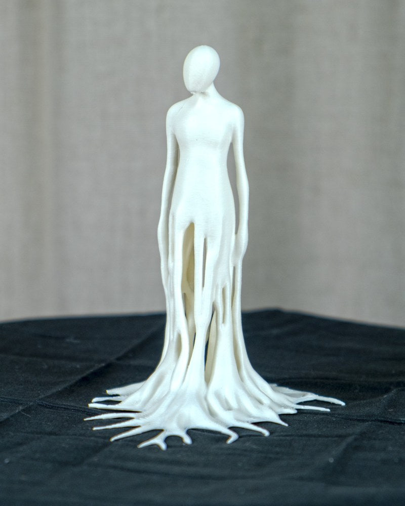 Close-up of a melting man sculpture showing fluid, dripping human figure form on a white surface