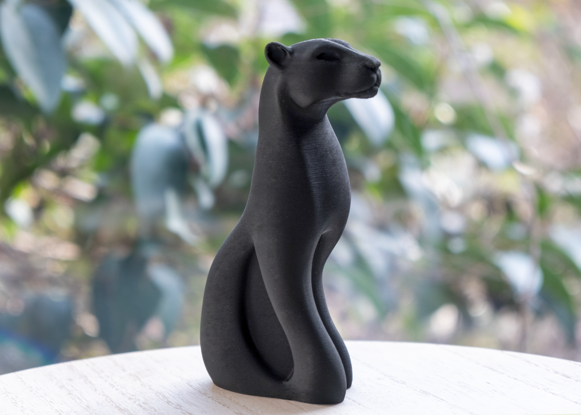 Black panther sculpture styled on a wooden sideboard with minimal Scandinavian decor