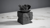Eternal Bloom black rose sculpture styled on a dark wooden desk beside books