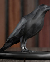Low poly crow sculpture in dark geometric form, close-up on faceted surface detail