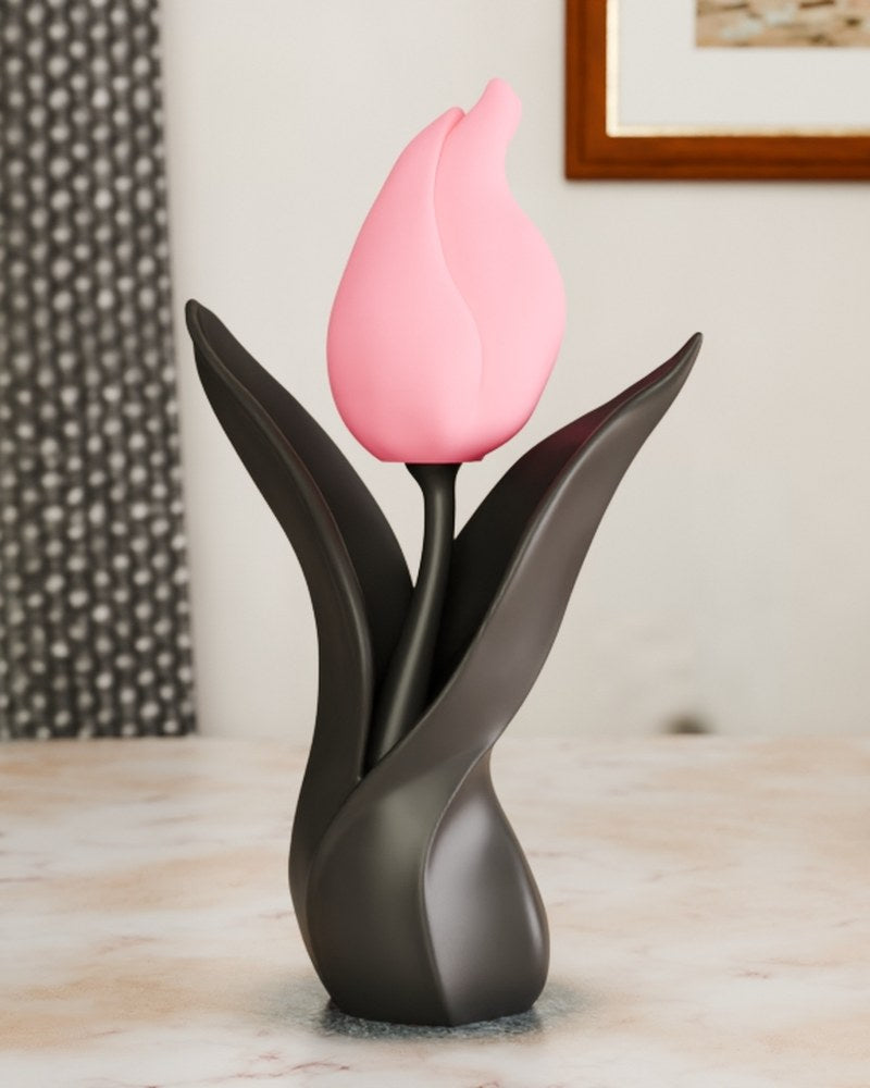 Close-up of a minimalist tulip sculpture with black base and curved petals against a light background