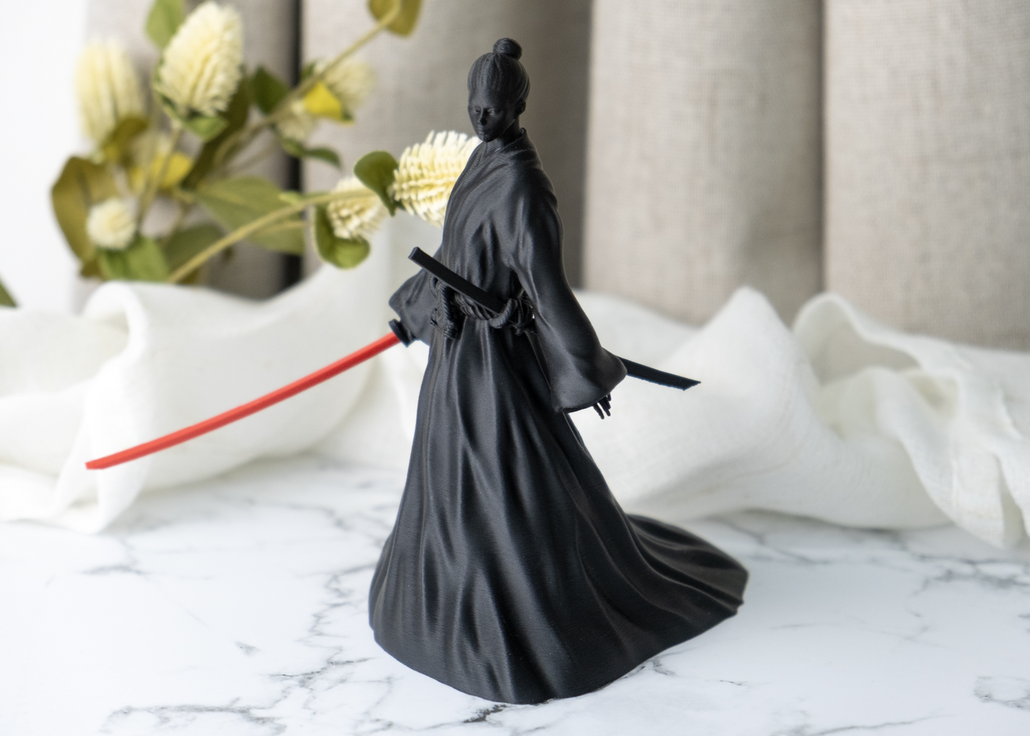 Onna-bugeisha figurine styled on a dark wood desk alongside minimal decor objects