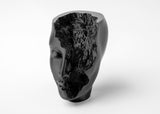 Abstract face sculpture styled on a minimalist shelf with neutral decor and soft natural light