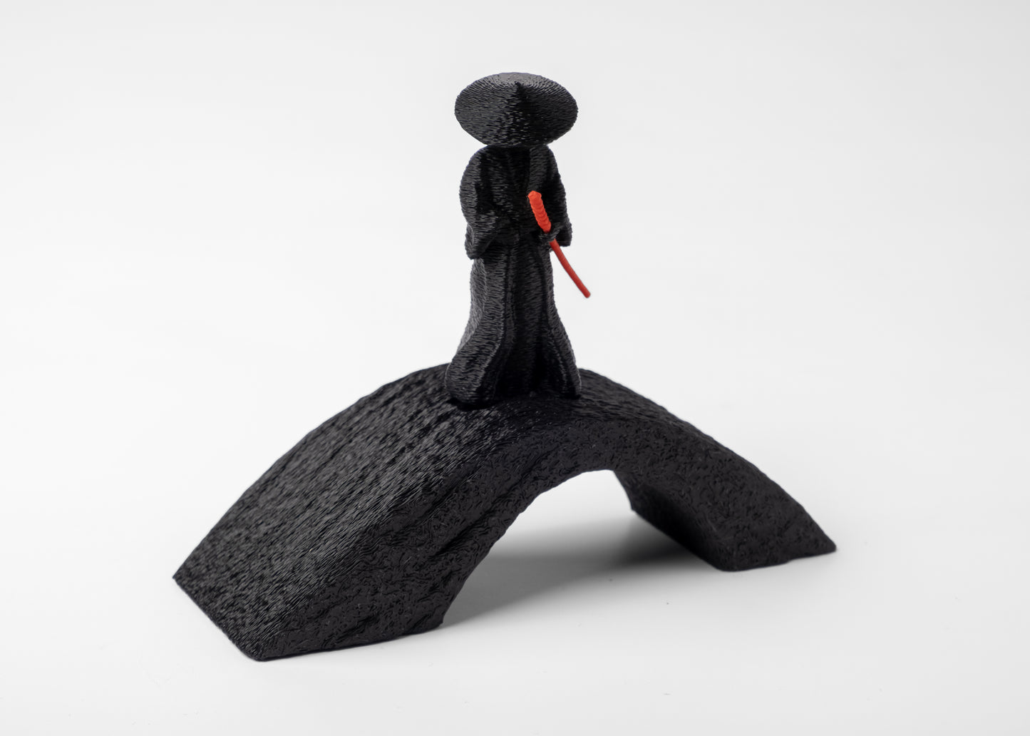 Samurai sculpture styled on a wooden desk with small ceramic and natural objects