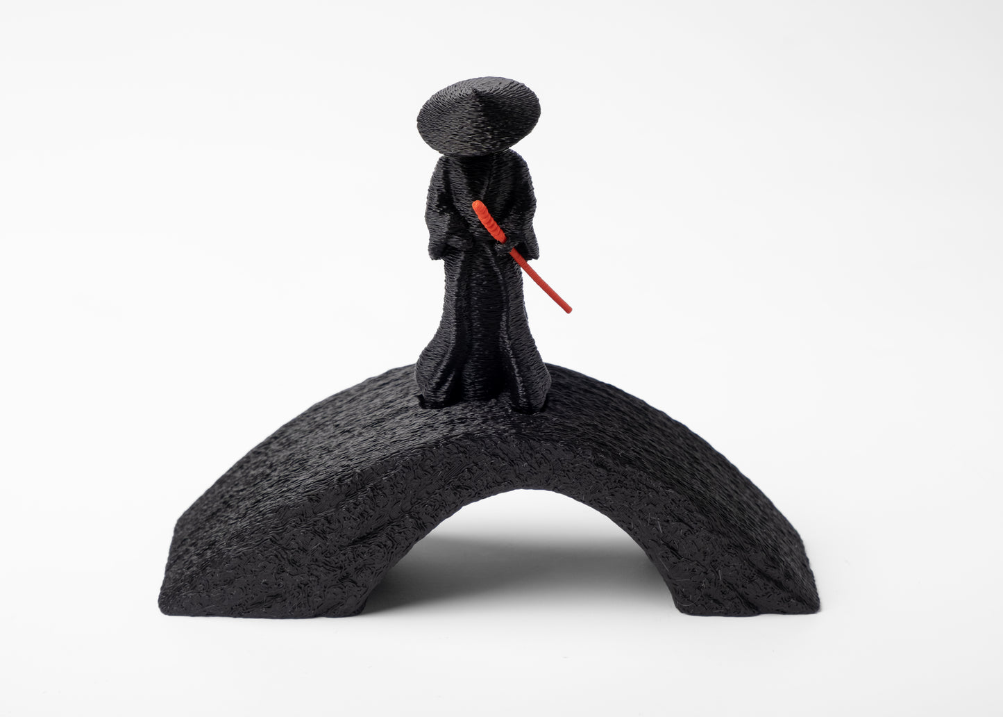 Close-up of samurai figure detail — flowing robe and conical hat in muted finish