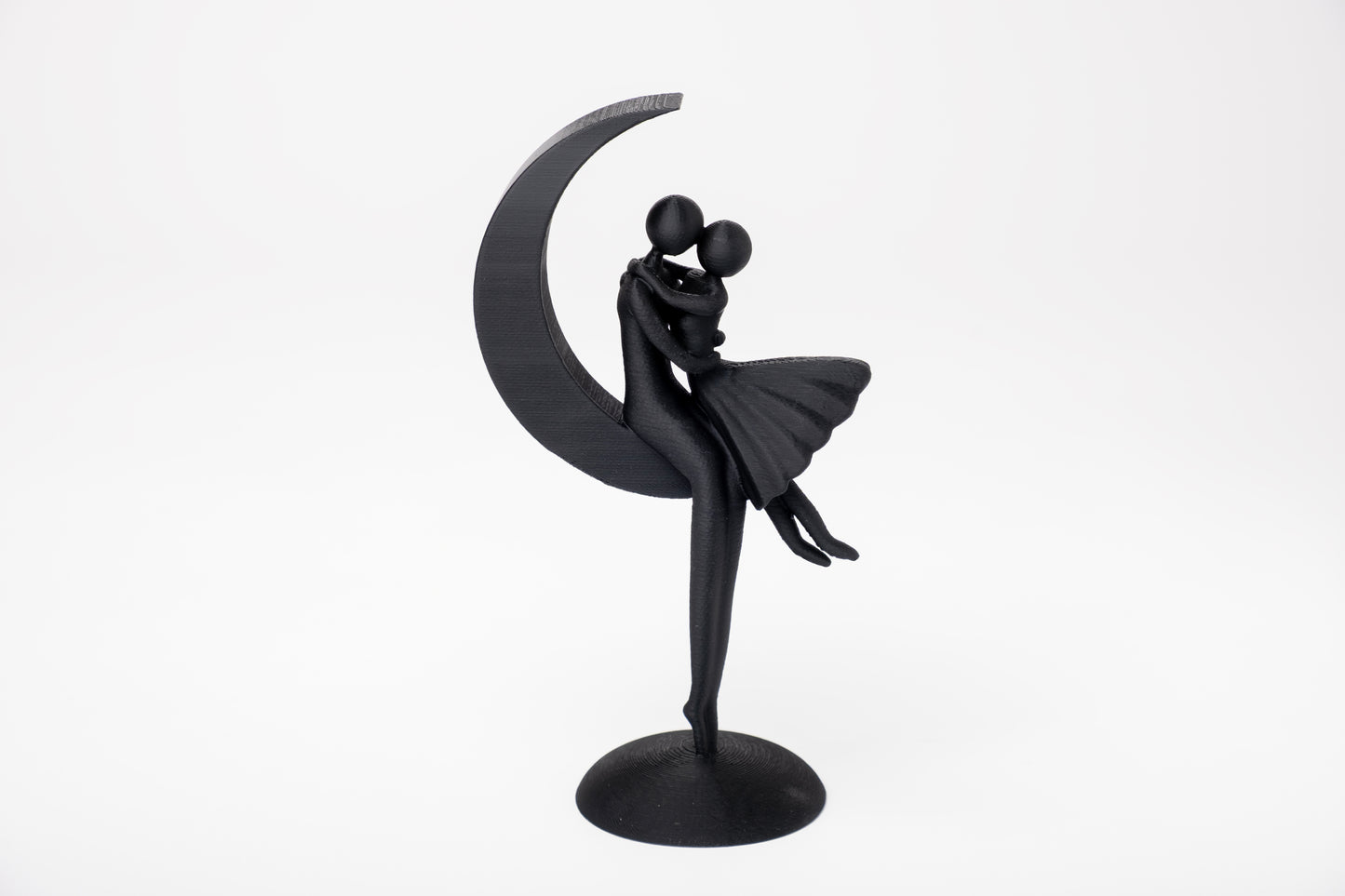 Minimalist couple moon sculpture styled on a wooden shelf with soft neutral decor