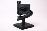 The Witness surreal sculpture styled on a dark wooden desk alongside minimal decor objects