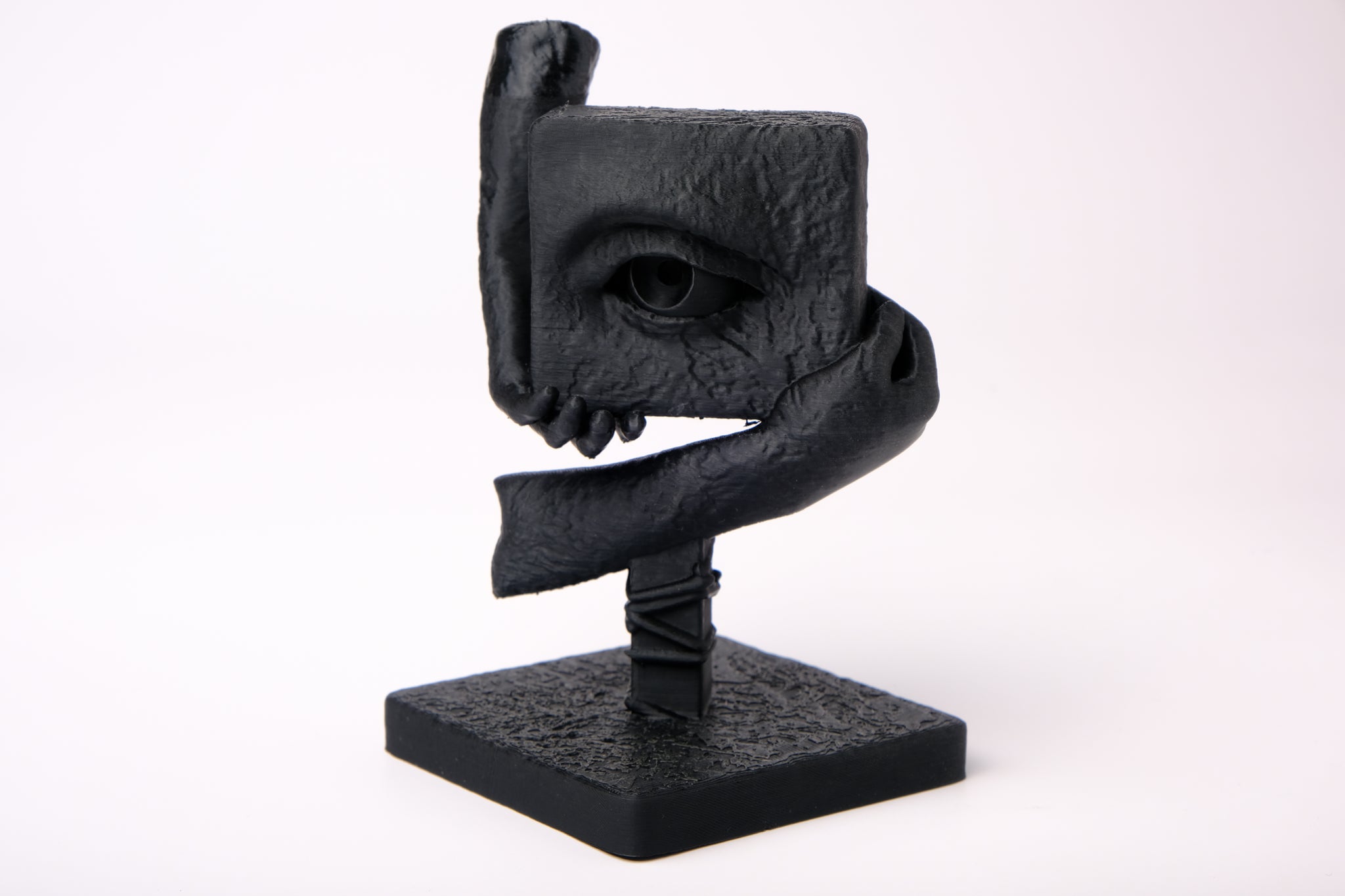 The Witness surreal sculpture styled on a dark wooden desk alongside minimal decor objects