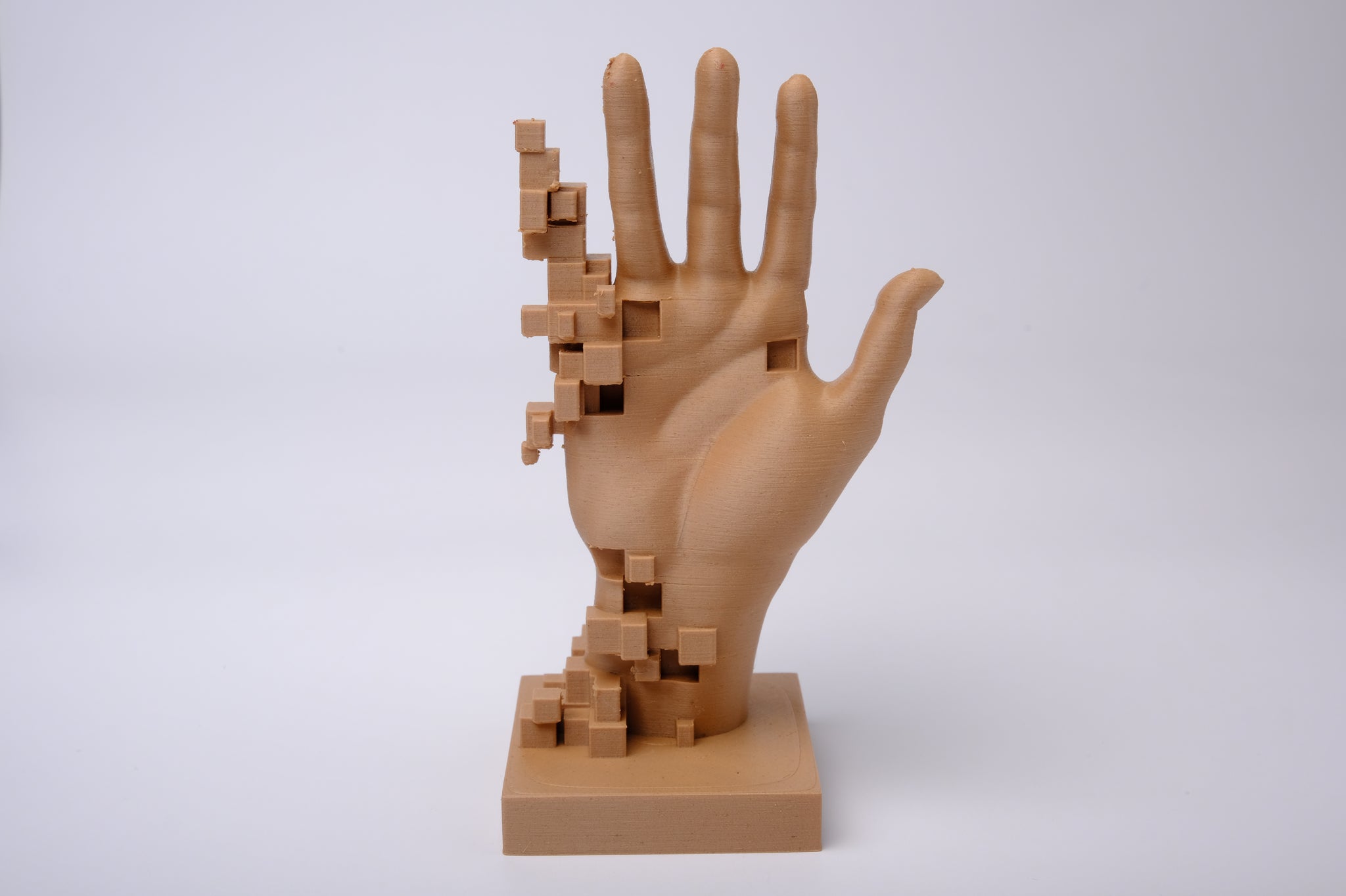 Glitch art hand sculpture styled on a minimal desk with books and a small plant