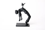 Bird of Burden sculpture styled on a minimal wooden shelf beside books and a small ceramic vessel
