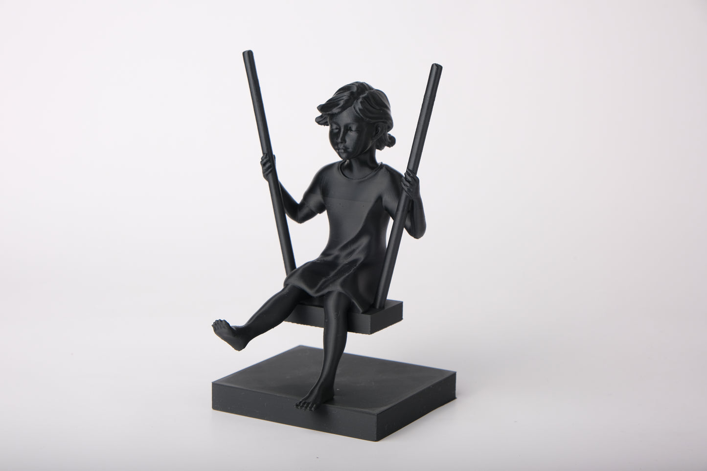 Girl on a swing sculpture styled on a wooden shelf with neutral Scandinavian decor
