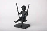 Girl on a swing sculpture styled on a wooden shelf with neutral Scandinavian decor