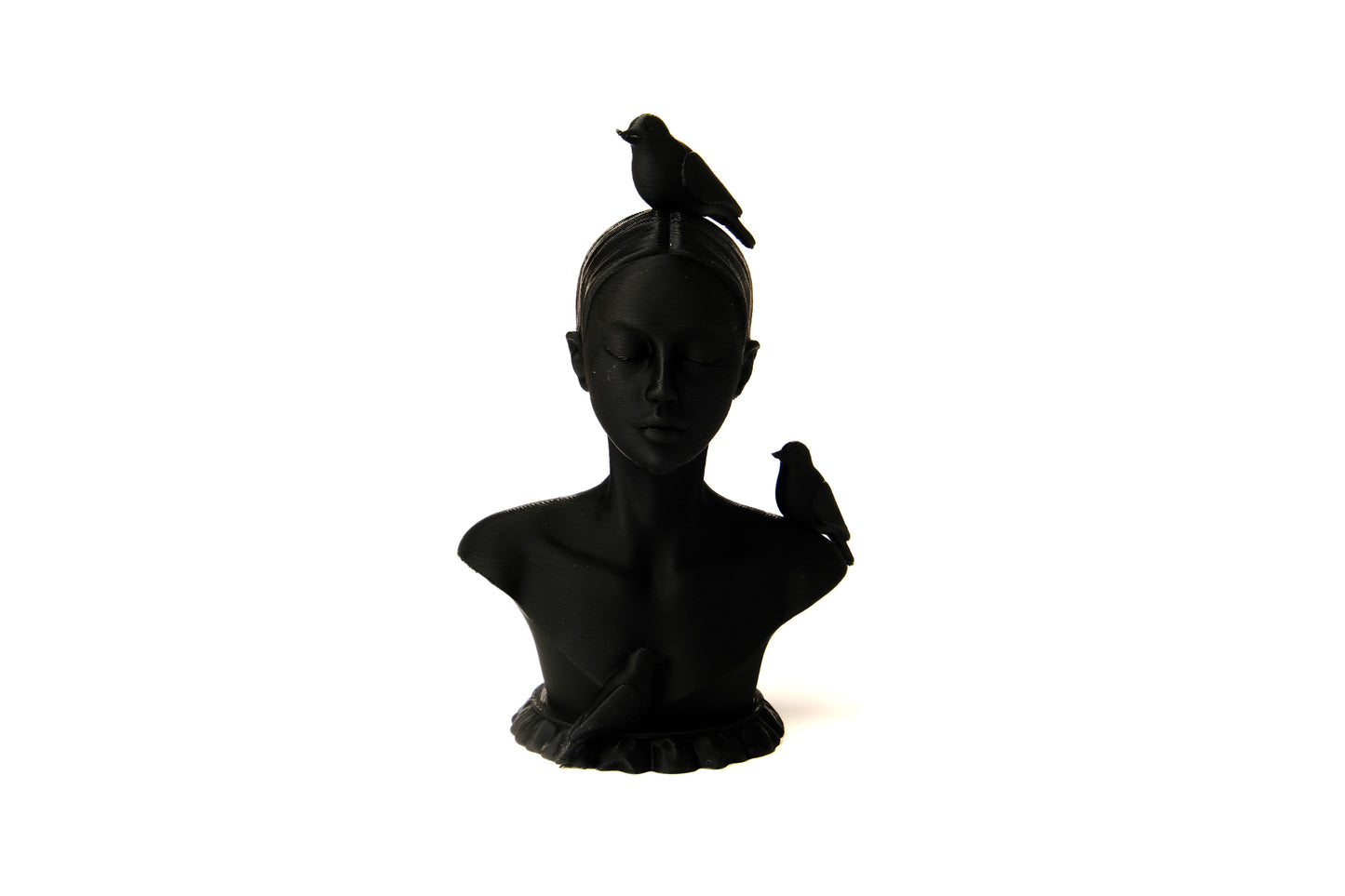 Woman and birds bust sculpture styled on a minimal shelf with books and a dried plant