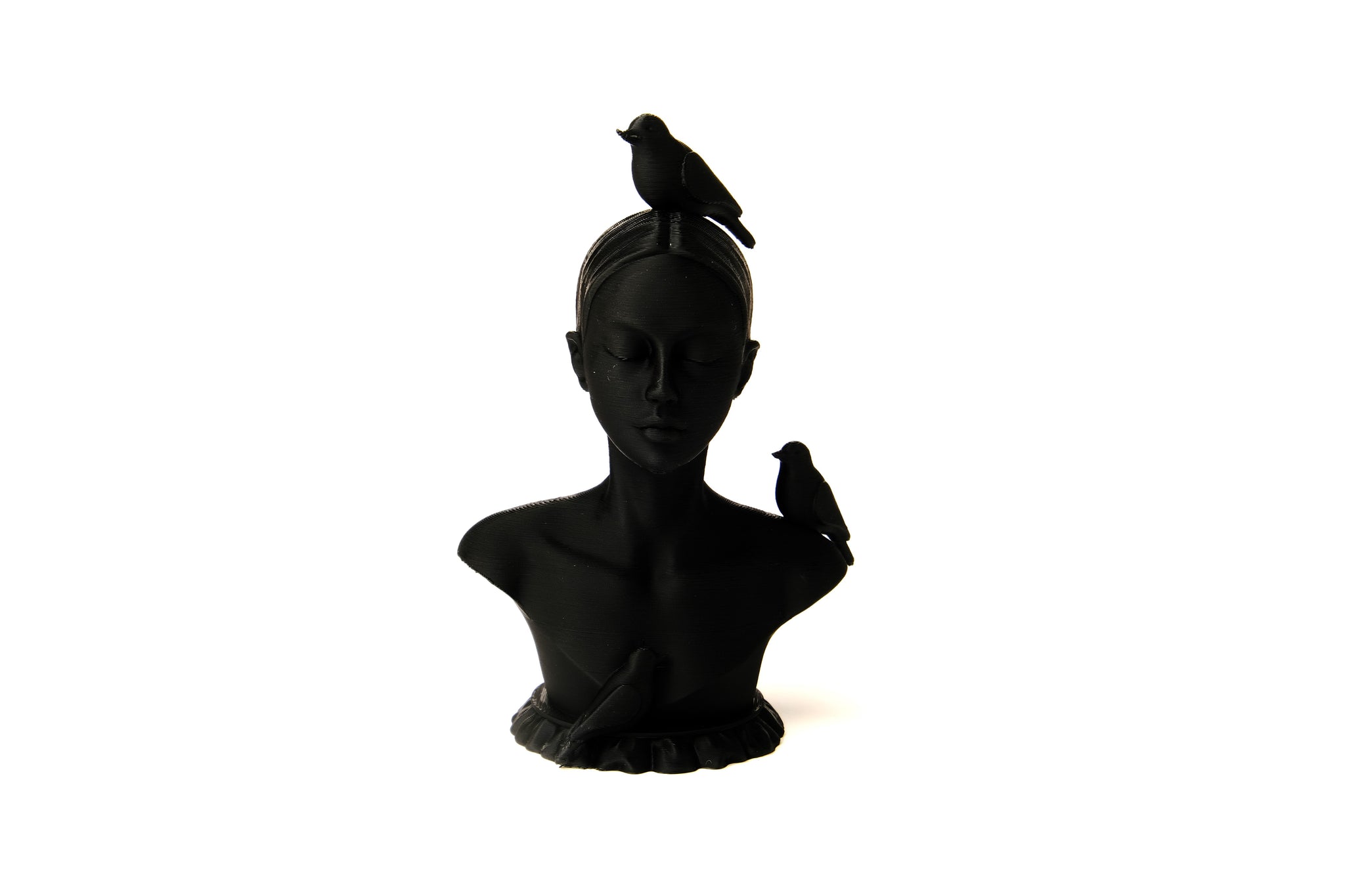 Woman and birds bust sculpture styled on a minimal shelf with books and a dried plant