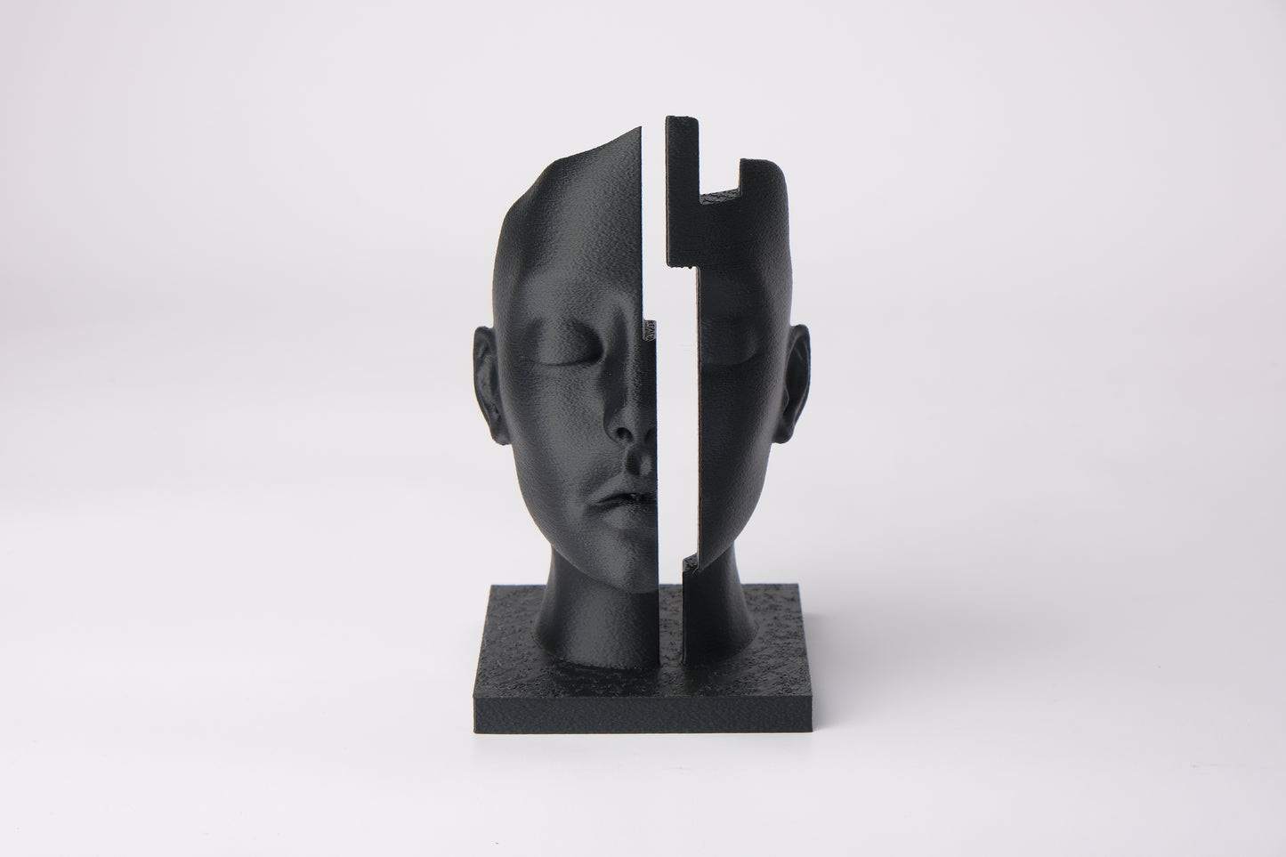 Mind Gap abstract bust styled on a dark wood shelf alongside minimal decor objects