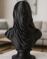 Matte black veiled bust sculpture on a white surface, close-up showing draped veil texture